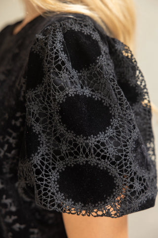 The top features stylish puff sleeves which are beautifully finished with delicate lace accents at the cuffs, adding an exquisite touch of femininity and elegance to the classic silhouette. Effortlessly versatile, this piece can be dressed up for evenings out or easily paired with denim for a chic, elevated everyday look. A must-have for adding texture and refinement to any outfit.