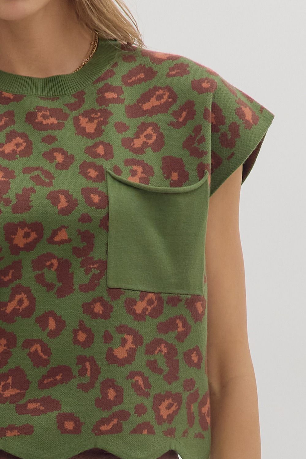 Animal print cap sleeve knit top featuring chest patch pocket and scallop edge hem. Unlined. Knit. Non-sheer. Lightweight.